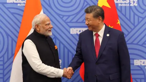 Biro Informasi Pers Perdana Menteri India Narendra Modi berjabat tangan dengan Presiden Tiongkok Xi Jinping sebelum pertemuan mereka di sela -sela KTT BRICS di Kazan, Rusia, 23 Oktober 2024.