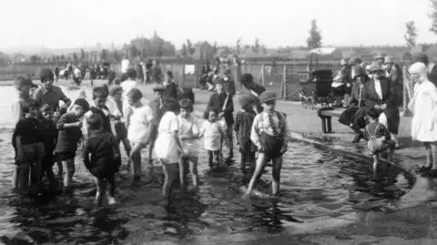 Vintage black and white image of children using the paddling pool