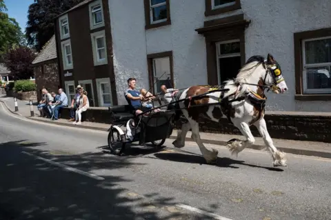 AFP/Getty Images People travel along The Sands street by horse and trap