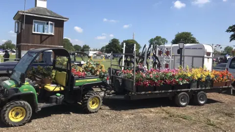 A tractor attached to a cart of flowers