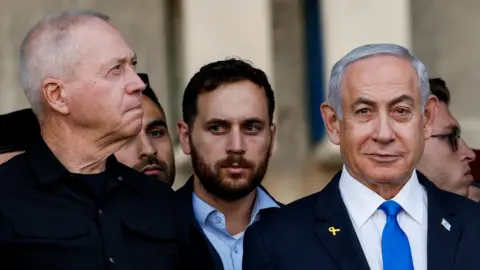 Yoav Gallant (left) stands next to Benjamin Netanyahu (right) during a ceremony at an Israeli military base near Mitzpe Ramon, Israel, October 31, 2024.