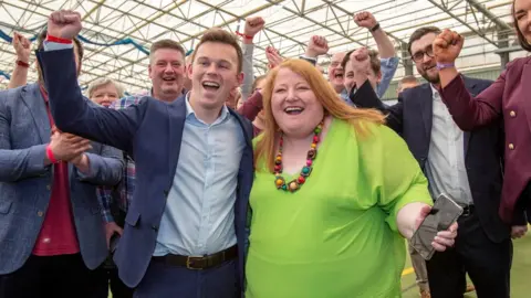 Getty Images / PAUL FAITH Naomi Long with Eoin Tennyson celebrating election win