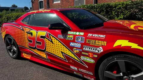 Jack Maclean/BBC A red Chevrolet Camaro with lightning bolts across the exterior and the number 95.