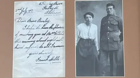 Snapshot images of postcards from Mr Hills, the image on the left shows his handwriting and on the right a black and white photograph of a man in military uniform standing next to a woman in a white blouse and long skirt with her hair tied back in a low bun