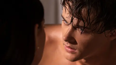 Erika Doss/Prime A close up picture of a man with wet hair and blue eyes looking into the eyes of a woman - you can see the back of her head