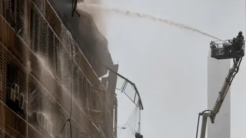 A fireighter works on a building in the aftermath of a missile strike from Iran on Israel, at Soroka Medical Center, in Beersheba. 