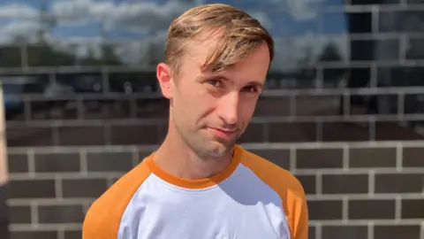 Sam Read/BBC Man with orange and white t shirt outside Stadium MK