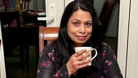 West Suffolk NHS Foundation Trust Ms Ramasamy holding a cup of tea with the ring on display