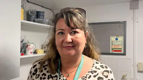 Michelle Robinson, a store manager for The Children’s Society store in Northenden poses for a photo in a backroom kitchen.