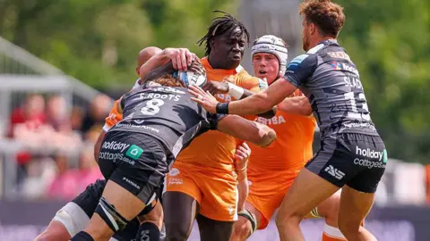 Asher Opoku-Fordjour is tackled by Saracens players