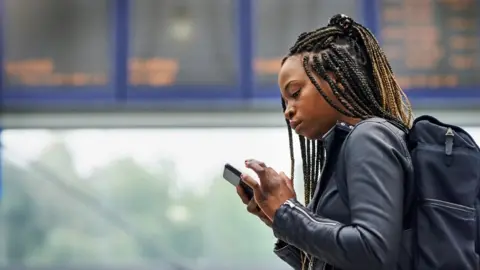 Getty Images Woman waiting on train platform