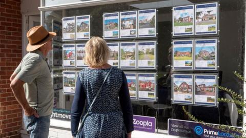 People looking at estate agent's window