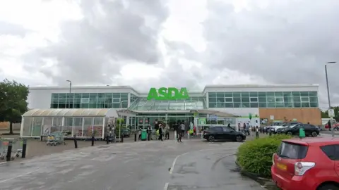 Google An Asda supermarket in Sinfin, Derby. The Google Streetview image shows the front of the supermarket taken from the car park. 
