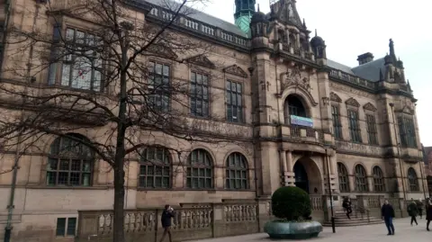 Sheffield town hall is a large stone built Victorian building with arched windows and ornate stonework
