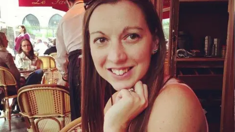 Mike Barnes Laura is resting her head on her left hand as she smiles at the camera in a restaurant. 