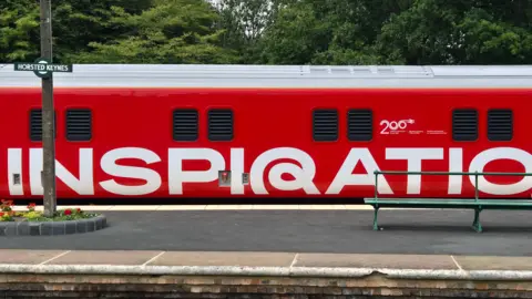 The Inspiration Train, in its red and white livery with 'Inspiration' painted on the side, pulled up at Horsted Keynes station on the Bluebell Line in Sussex.