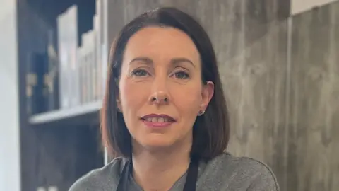 Marie Hall wearing a grey t-shirt 