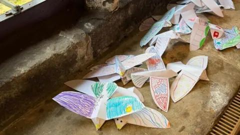 Toby Hammond Paper birds created and coloured in by children 