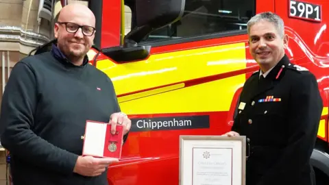 DWFRS Neil Luton getting his award from the chief fire officer