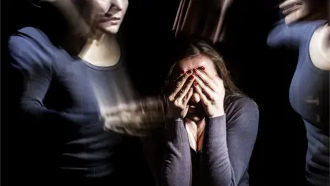 Getty Images A woman with her hands over her face