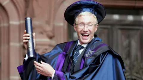 PA Media File photo dated 22/07/05 of Paul O'Grady after receiving an honorary fellowship from Liverpool John Moores University for services to entertainment.