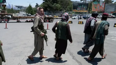 Getty Images Taliban fighters patrol along a blocked street ahead of the council meeting of tribal and religious leaders in Kabul