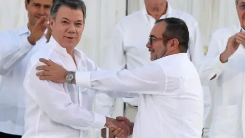 AFP President Santos and Timochenko shaking hands after signing a peace deal