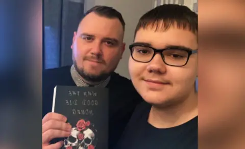 Contributor image Mckenzy with his dad holding the novel
