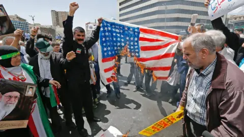 AFP Iranian protesters burn a painted US flag at a rally in Tehran on 10 May 2019