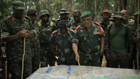 Getty Images Major General Camille Bombele, coordinator of the Joint Armed Forces of the Democratic Republic of Congo-Ugandan People's Defence Forces Military Operations talking with officers at the headquarters in the Virunga National Park on 17 December 2021