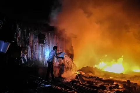 Getty Images A man struggles to put out a night fire that razed down homes, leaving most families homeless during late-night hours in Kibera, Nairobi. Residents of Kibera Slums experienced another loss as they were caught unaware by a fire that occurred late in the night, razing down twenty homes, leaving most locals homeless and with nowhere to turn to. The fire eruption was due to tangled wires from illegal electric connections.