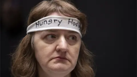 EPA A woman wearing a "hungry hostage" headband protests on Capitol Hill