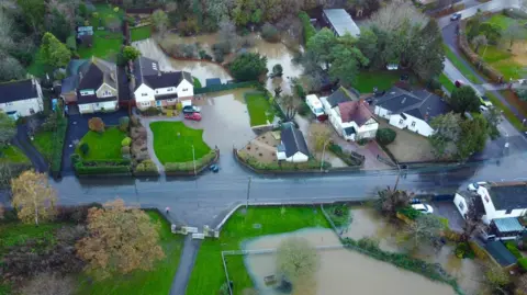 An aerial drone shot of housing in Melksham surrounded by floodwater