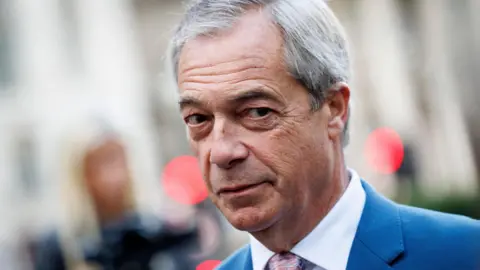 Nigel Farage's head and shoulders. He is looking to the side and appears straight-faced.