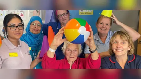  Peterborough City Hospital Hospital staff with a patient who is holding a beach ball on the ward