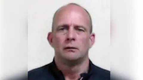 A head shot of David Brown, a man with a shaven head looking directly into the camera.