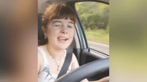 Amber Potter winks and sticks out her tongue while driving