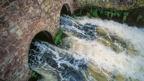 Waste water from large sewage treatment plant flowing directly into a river