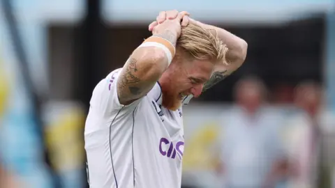 England captain Ben Stokes puts his hands on his head as he leaves the field injured