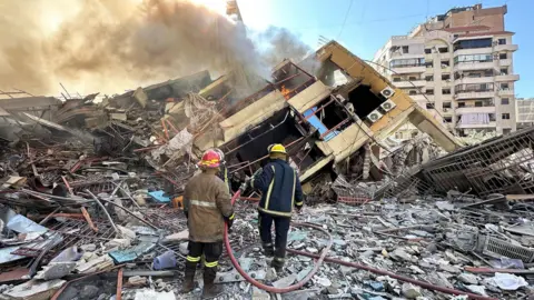 Members of the Lebanese Civil Defence inspect a damaged building after an Israeli strike on Beirut's southern suburbs, Lebanon (9 March 2026)