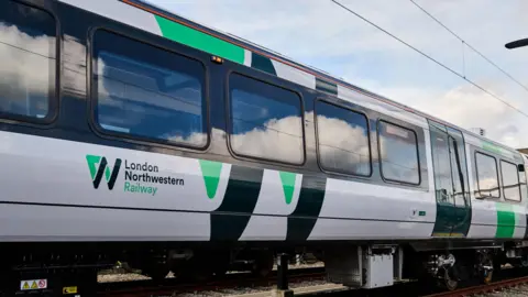 A LNR train, with green and black writing, showing several train windows. 