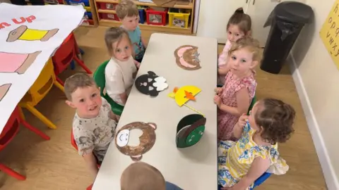 Six children sat around a table making masks for Appleby carnival.