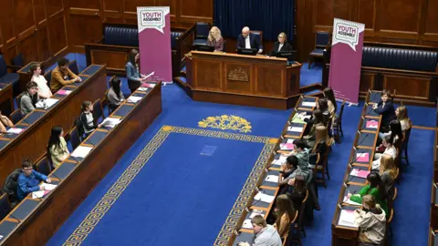 Michael Cooper The youth assembly in motion with deputy speaker john blair in the speakers chair and young people sitting in MLA seats. 