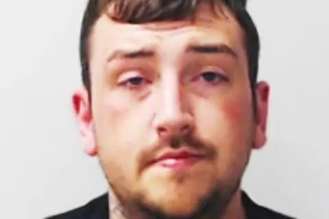 Police Scotland Police mugshot of Peter Garland, a man with stubble, looking at the camera.