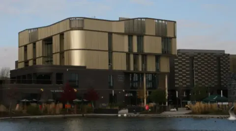 BBC Telford's Southwater One building, a curved-sided metallic building standing behind a lake