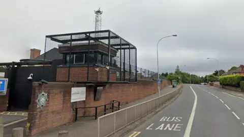 An area of road near to where the incident happened - it shows a police station with a security cage and a road 