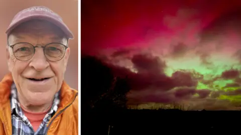 Chris Moss on the left of the picture wearing a red cap, glasses and a yellow jacket and on the right the northern lights in purple and green.