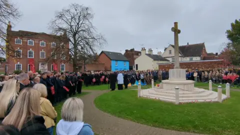 Residence from Ringwood, Hampshire, stood to pay their respects in front of the village War Memorial