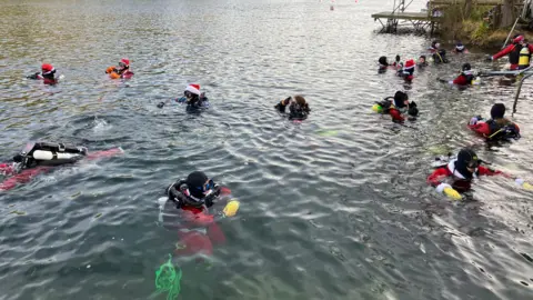 About 20 divers can been seen treading water dressed in their Santa consumes and with their googles on, about to dive. 
