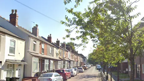 Leicester Street, Wolverhampton, a terraced street with cars parked on the left side of the road and trees lining the right